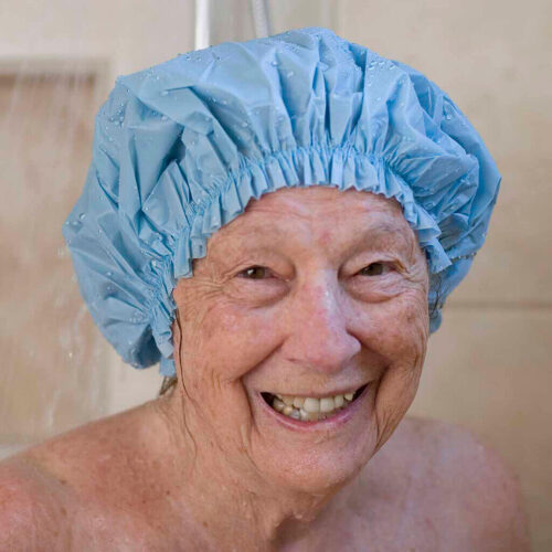 A woman smiling using a bathroom and shower product